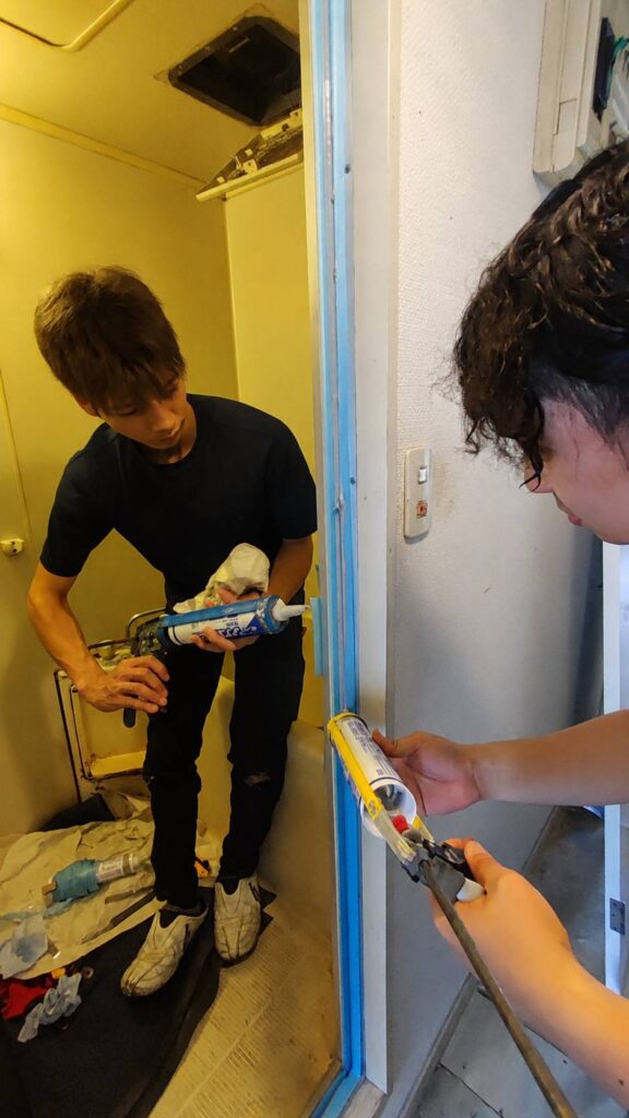 山陽小野田市で浴室ドア枠まわりを防カビシリコンで仕上げている様子
