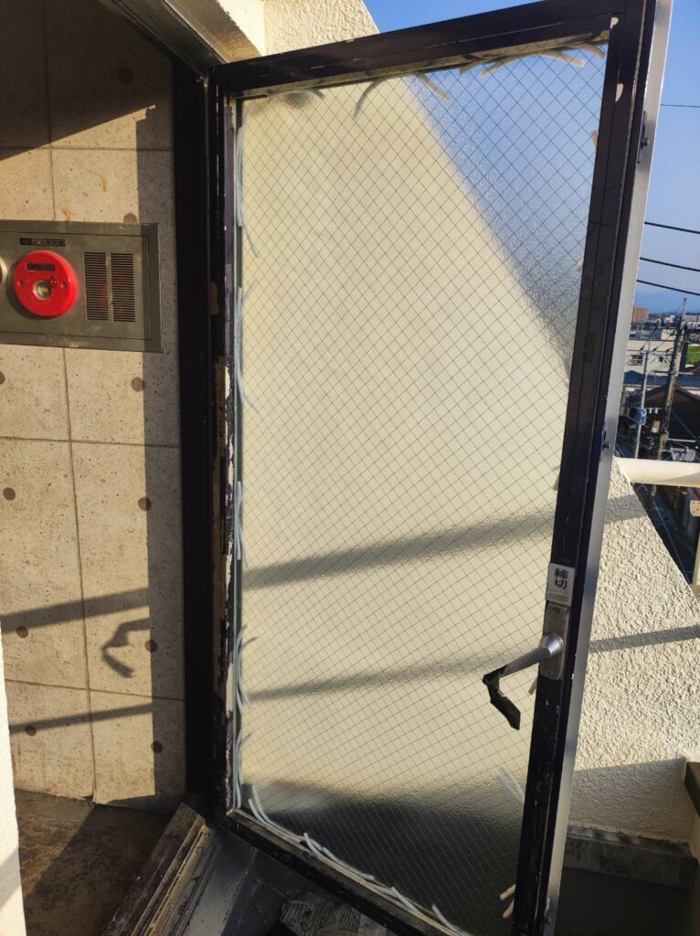 割れた網入りガラスと鏡を片開きドアから撤去する前の状態