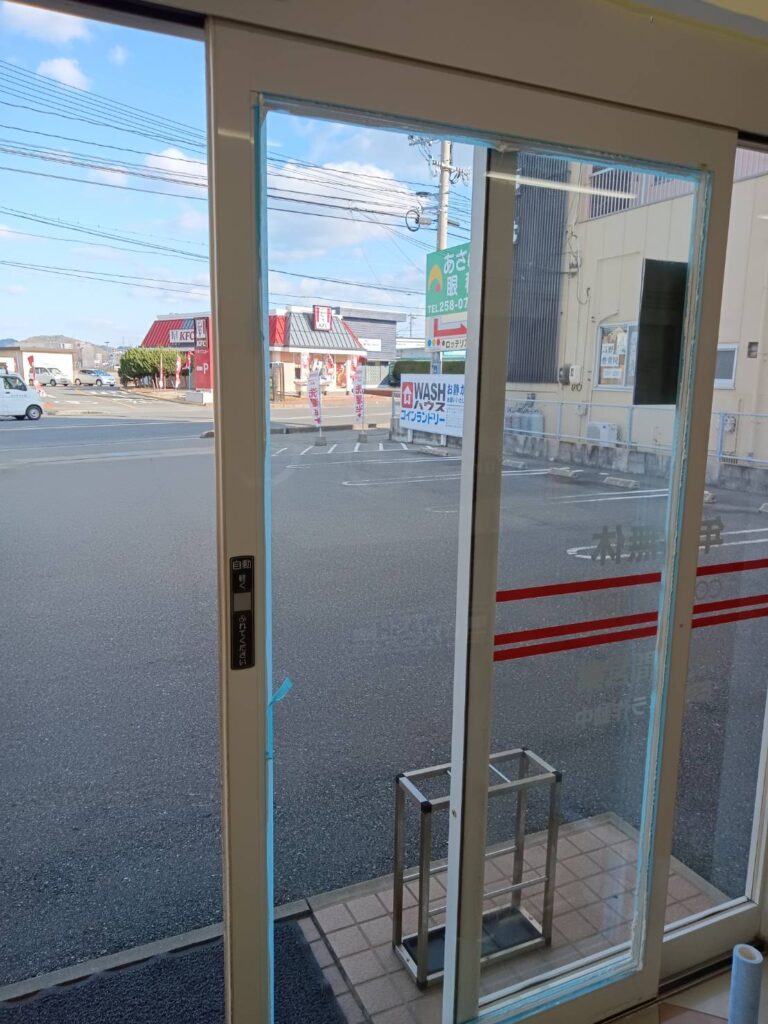 自動ドアガラスのコーキング施工中の様子