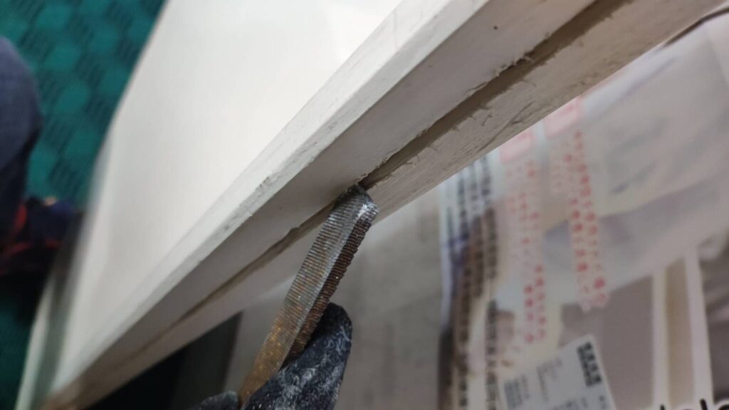 室内ドア用のガラスを定寸板から現地でカットしている様子