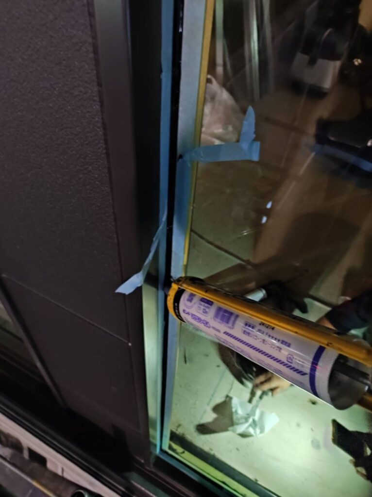 店舗ガラス交換後のコーキング施工中