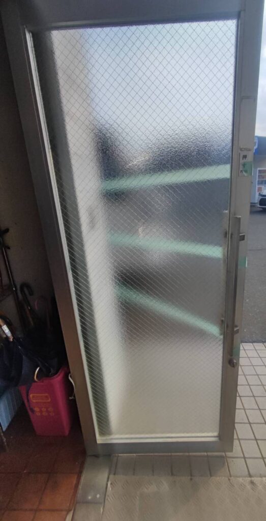 霞菱網入りガラスを店舗ドアへ仮固定した状態
