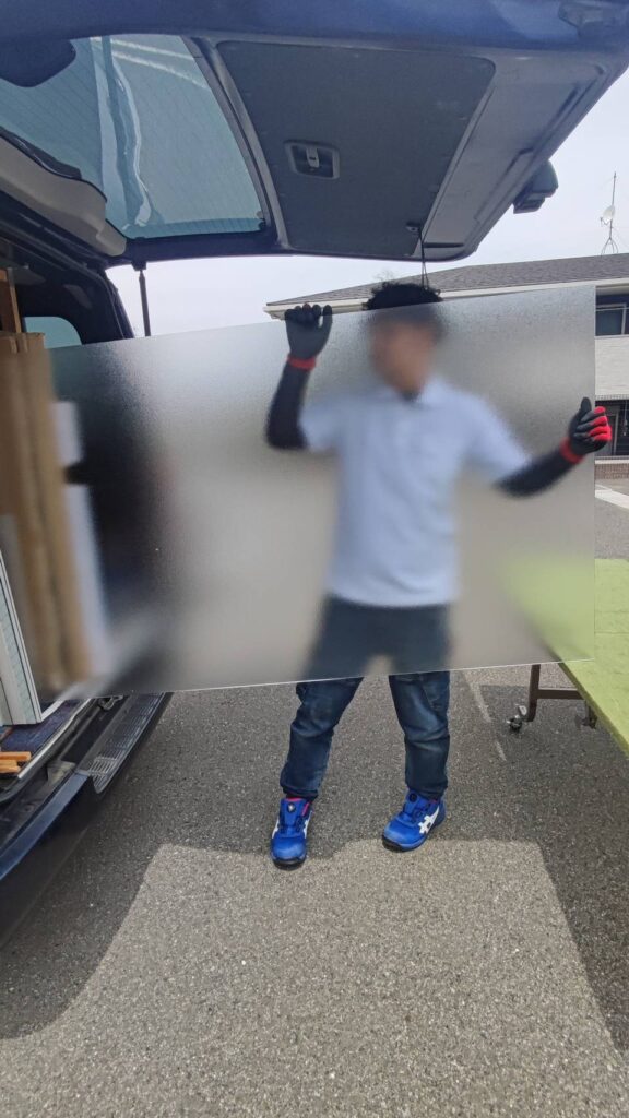 アパート窓に使用する新しい型板ガラスを準備している様子