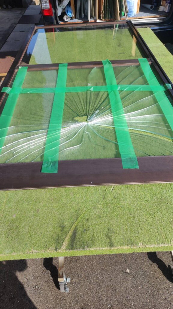 割れた型板ガラスを養生テープで固定した状態