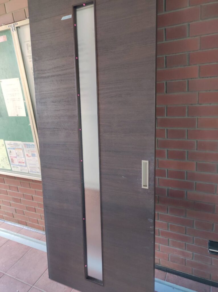 建具ガラス交換後に隠し釘でガラス押さえを再固定している様子