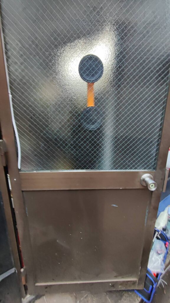 下関市で店舗ドアの網入りガラス交換を行う様子