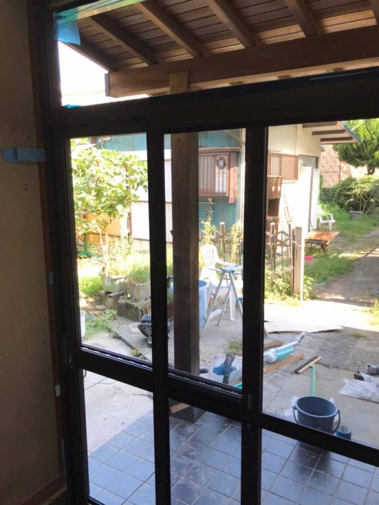 玄関引戸の新しいサッシ枠を調整して固定する作業