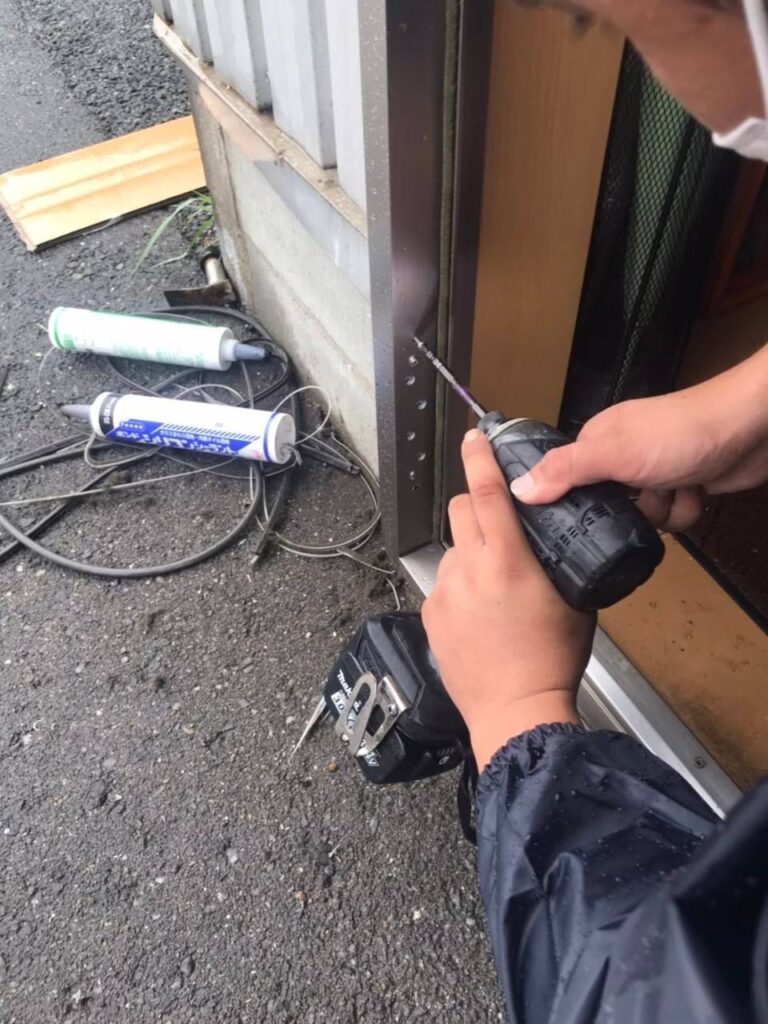 既存枠の内側へ新しい事務所ドア枠を設置する作業