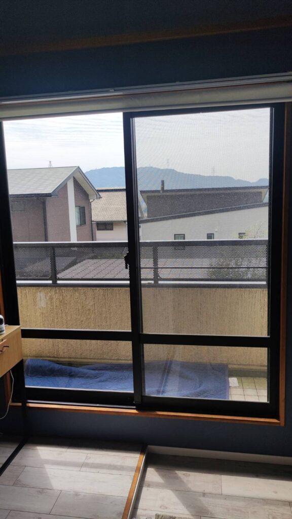 掃き出し窓に真空硝子を取り付けている作業風景