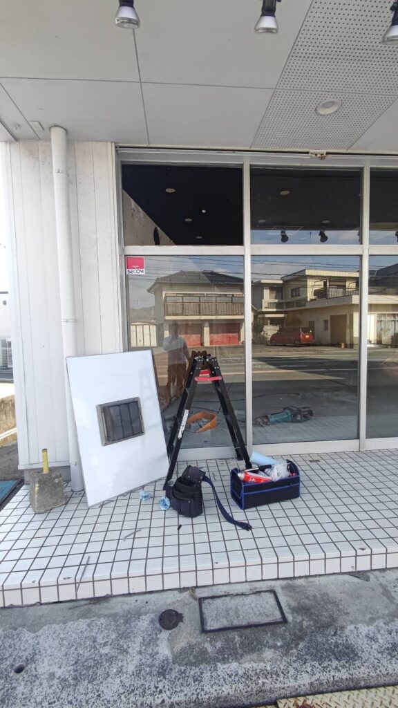 山口市の店舗フロントFIX窓で押し縁を外してアルポリック板を撤去している様子