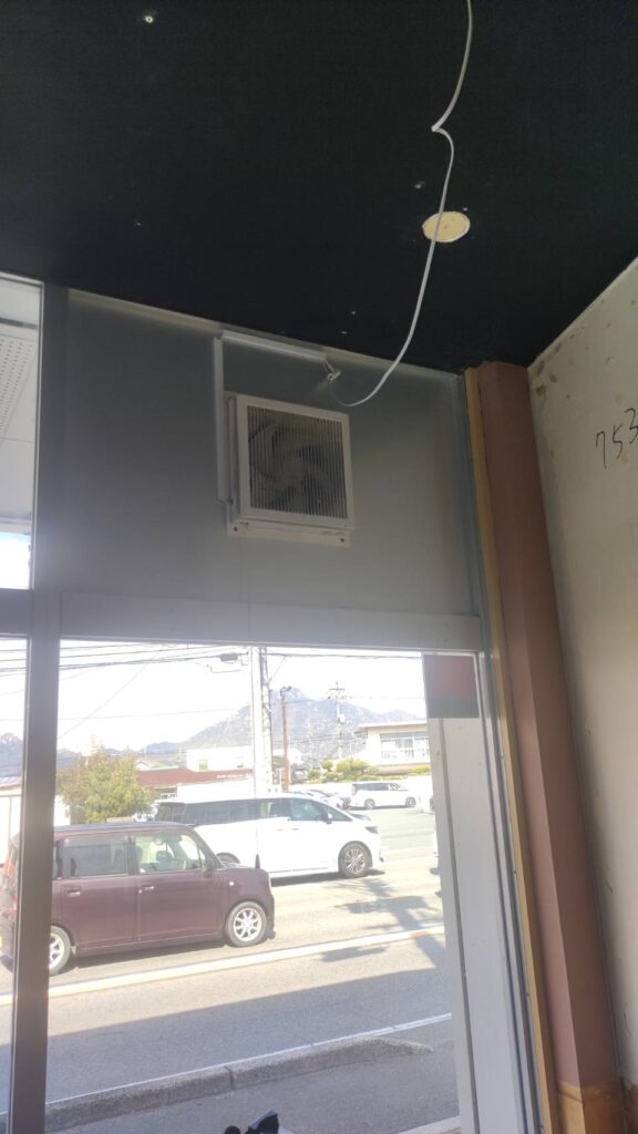 山口市の改装中店舗でフロントFIX窓ガラス交換前にアルポリック板と換気扇を確認している様子