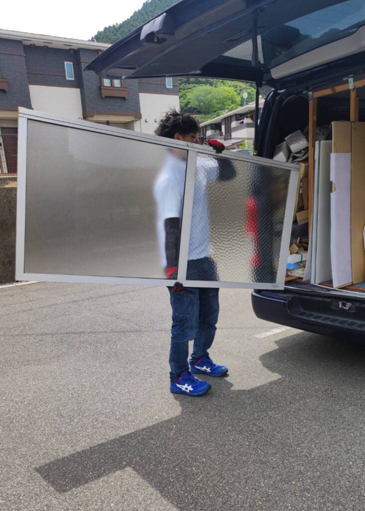 山口市でガラス修理に使用するガラス板を作業車に積載している様子